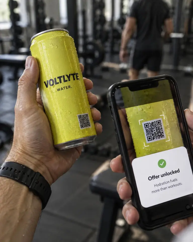 Concept image: a hand holds a Voltlyte can while a phone scans its QR code and shows Offer unlocked